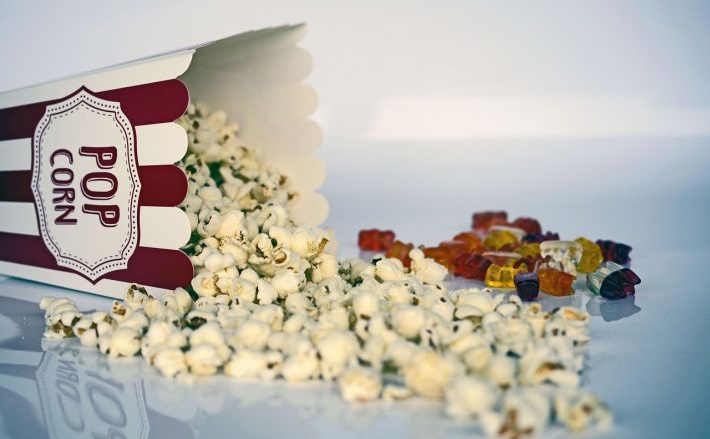 Foto: "Umgekippte Popcornschachtel mit Popkorn und Gummibärchen"
